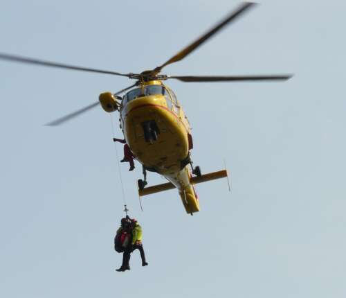 Rettungshubschrauber mit Menschen an Seilwinde