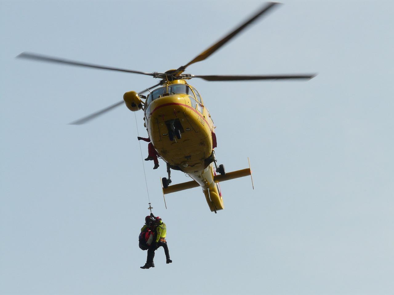 Rettungshubschrauber mit Menschen an Seilwinde