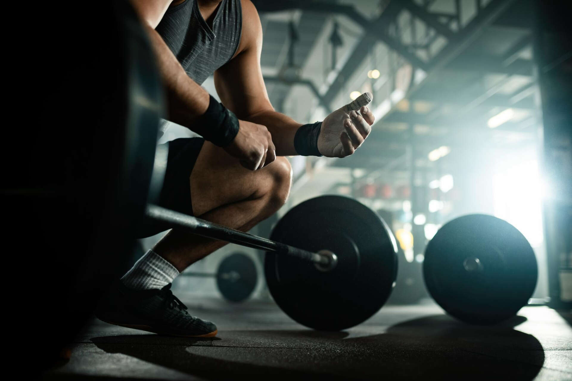 Ein Mann trainiert im Fitnessstudio an der Langhantel.