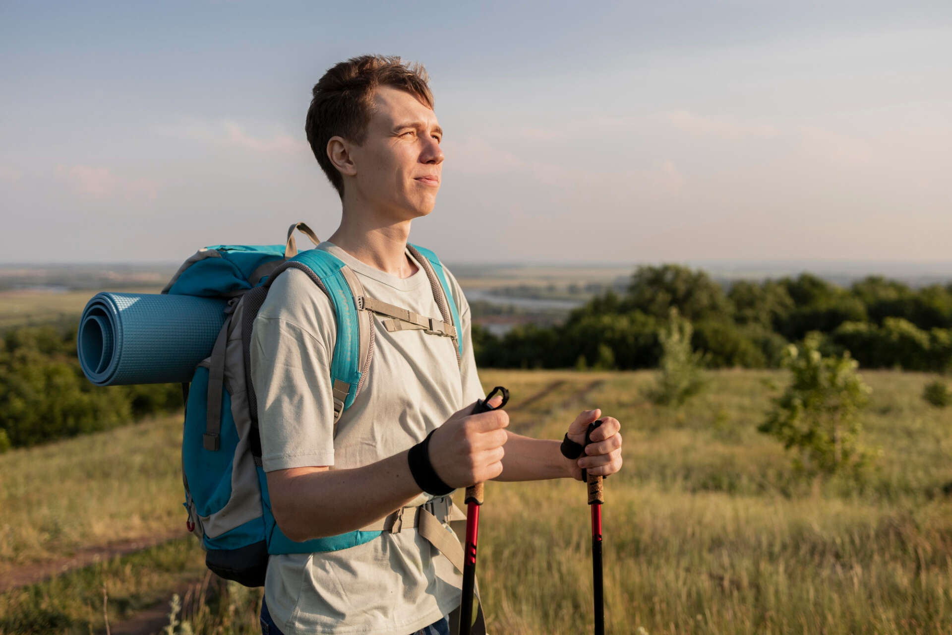Ein Mann mit Wanderrucksack und Wanderstöcken