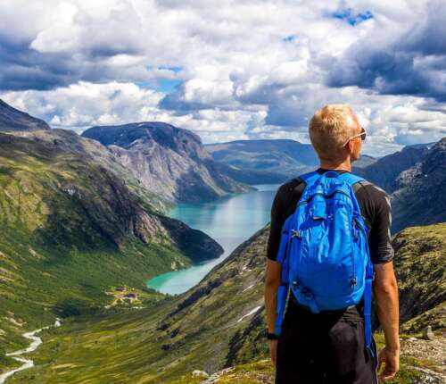 Wandern im Sommer: Ein Mann genießt die Aussicht auf einen Bergsee.