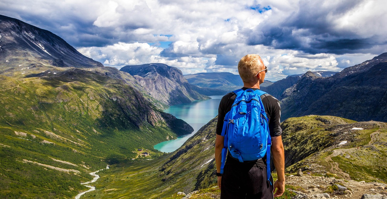 Wandern im Sommer: Ein Mann genießt die Aussicht auf einen Bergsee.