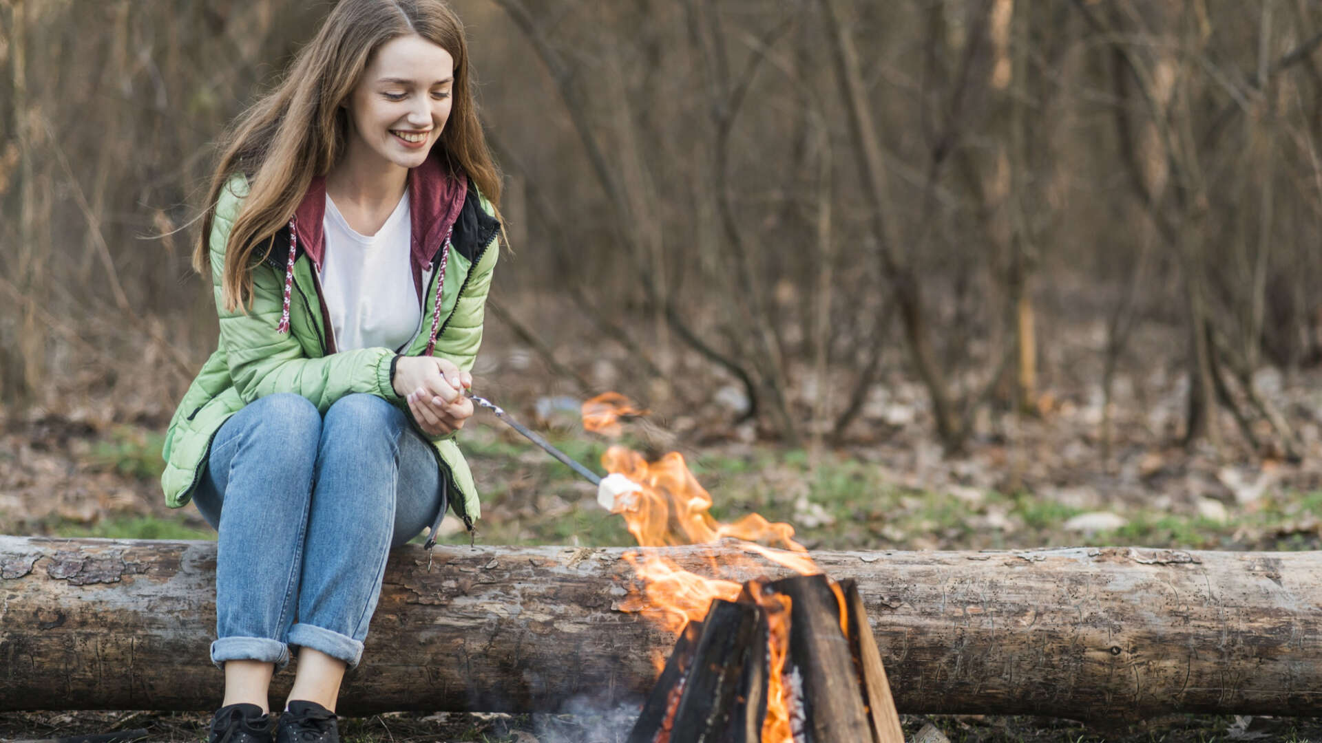 Eine Frau grillt Marshmallows über dem Feuer: Nach dem Wandern tut das besonders gut.