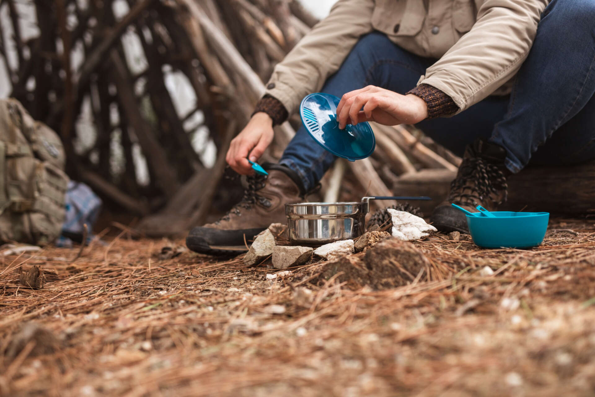 Outdoor-Kochen nach der Wanderung: Ein Mann bereitet sich draußen etwas zu essen zu.