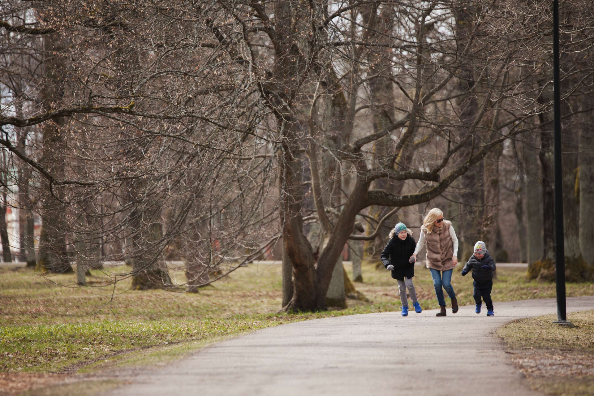 Eine Mutter mit ihren Kindern beim Wandern im Wald.