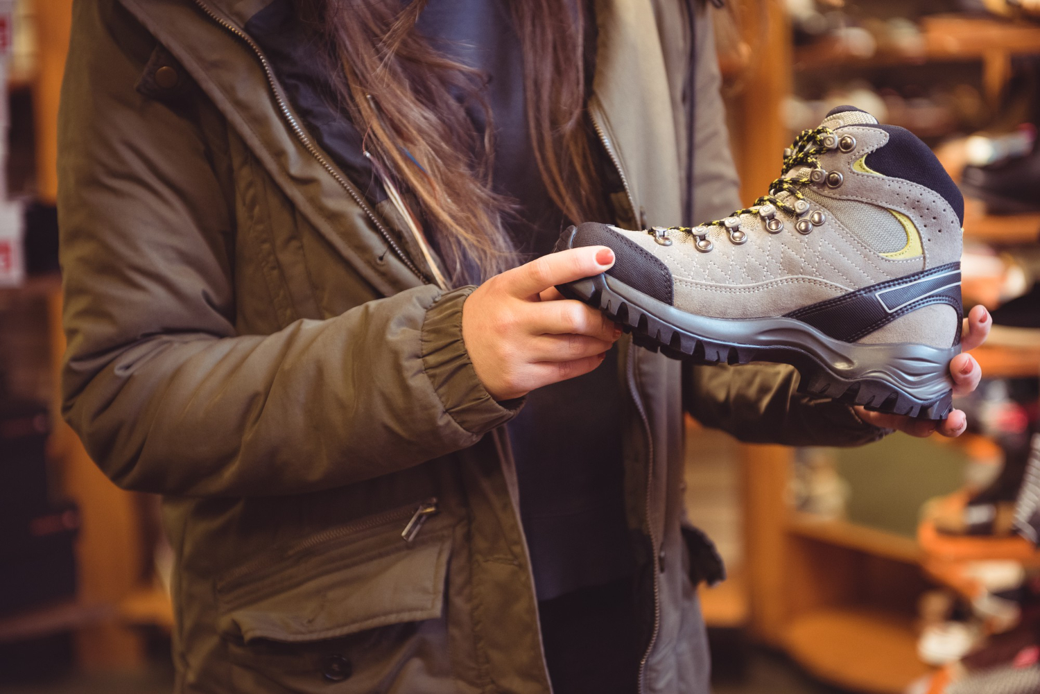 Eine Person schaut sich im Fachgeschäft Wanderschuhe an: Welche Größe ist die richtige?