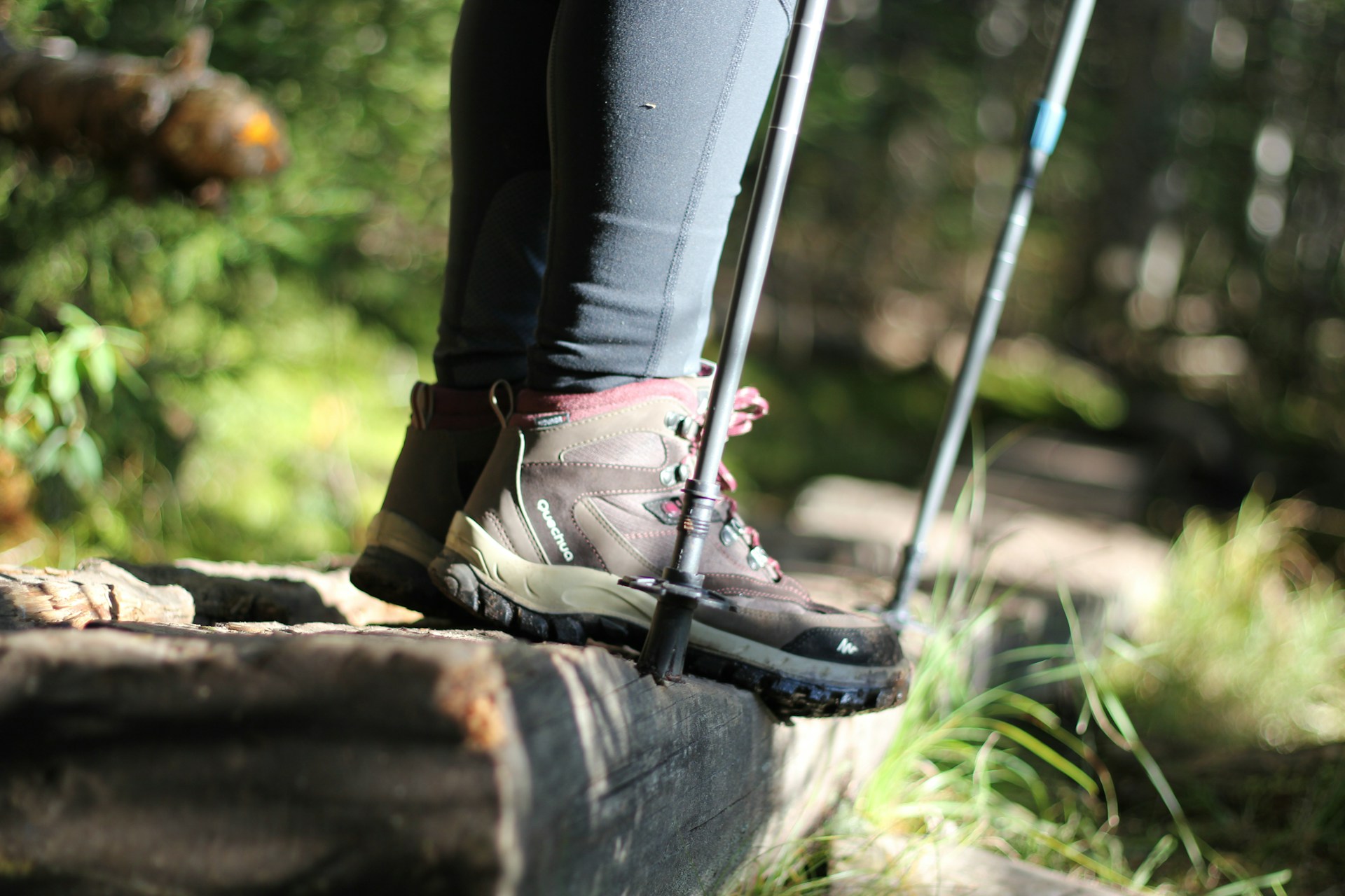 Eine Person auf Wanderung: Das Bild zeigt einen Ausschnitt von Wanderschuhen und Wanderstöcken.