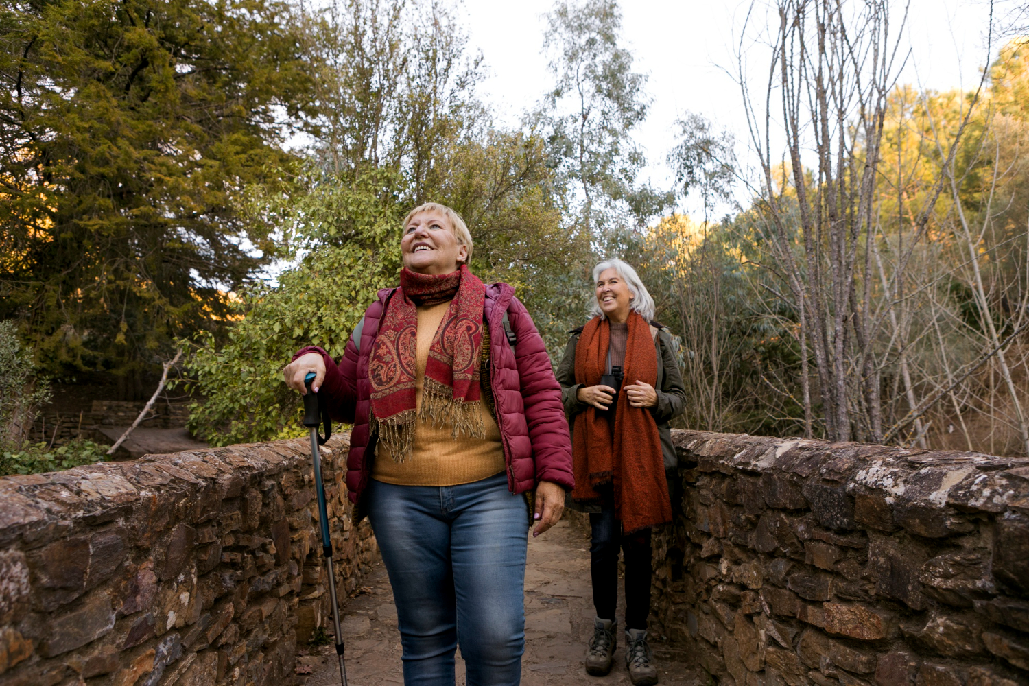 Zwei Frauen wandern gemeinsam und gut gelaunt durch die Natur.