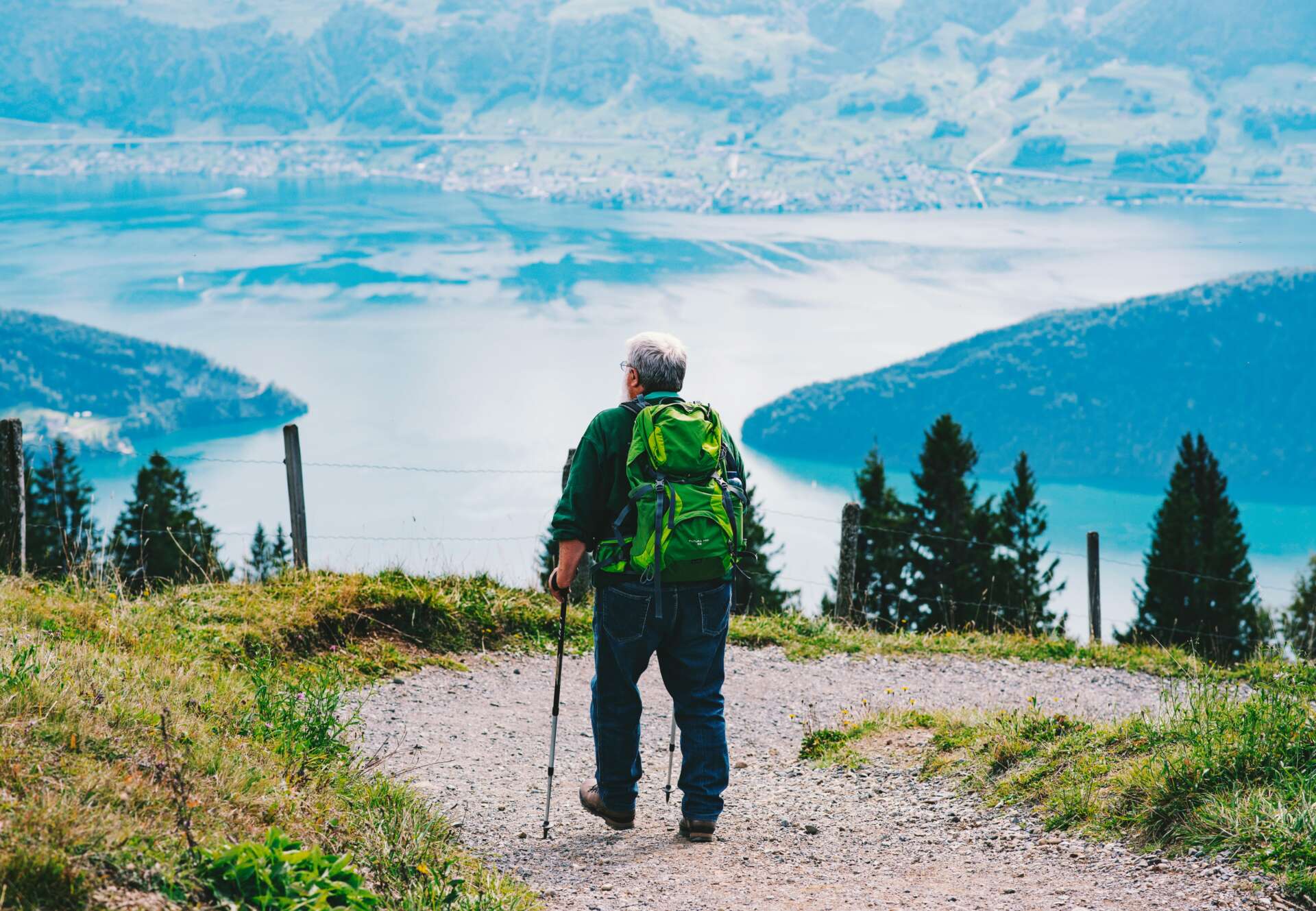 Ein älterer Mann beim Wandern auf einer Bergtour: Er genießt den Ausblick.