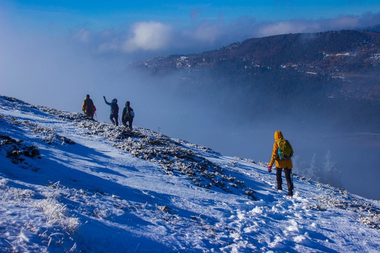 Gruppe wandert bei Minusgraden durch verschneite Berglandschaft