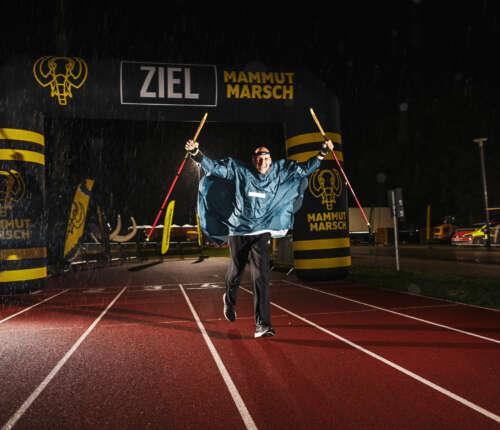 Teilnehmer läuft nach 100 Kilometern im Regen über die Ziellinie beim Mammutmarsch