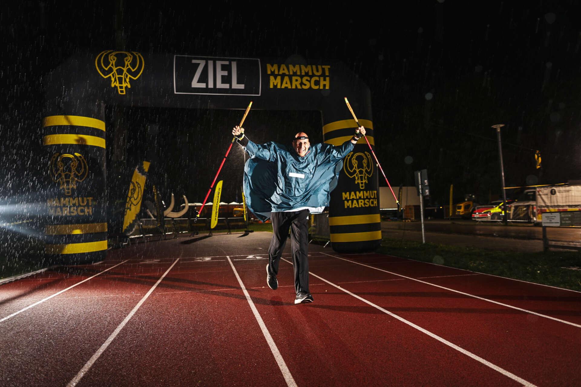 Teilnehmer läuft nach 100 Kilometern im Regen über die Ziellinie beim Mammutmarsch
