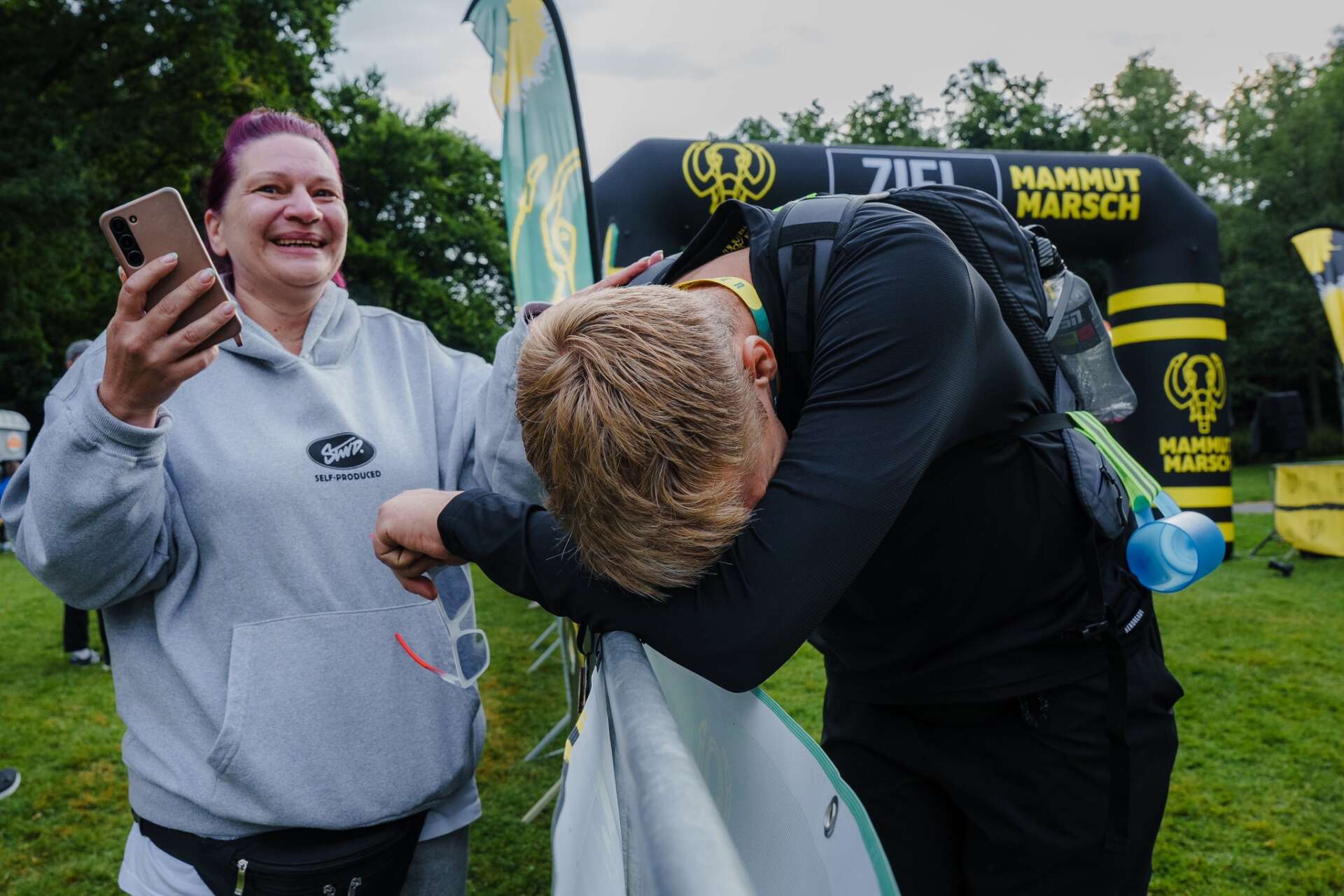 Erschöpfter Teilnehmer lehnt nach 100 Kilometern im Zielbereich des Mammutmarschs am Absperrgitter