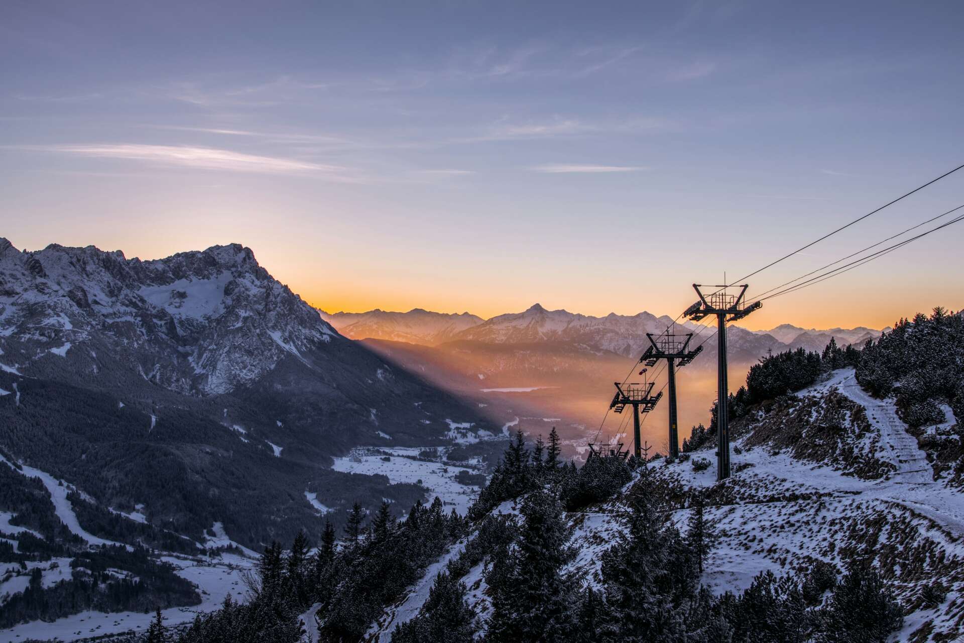 Winterlandschaft bei Garmisch-Partenkirchen mit verschneiten Bergen und Wanderweg entlang eines Skilifts
