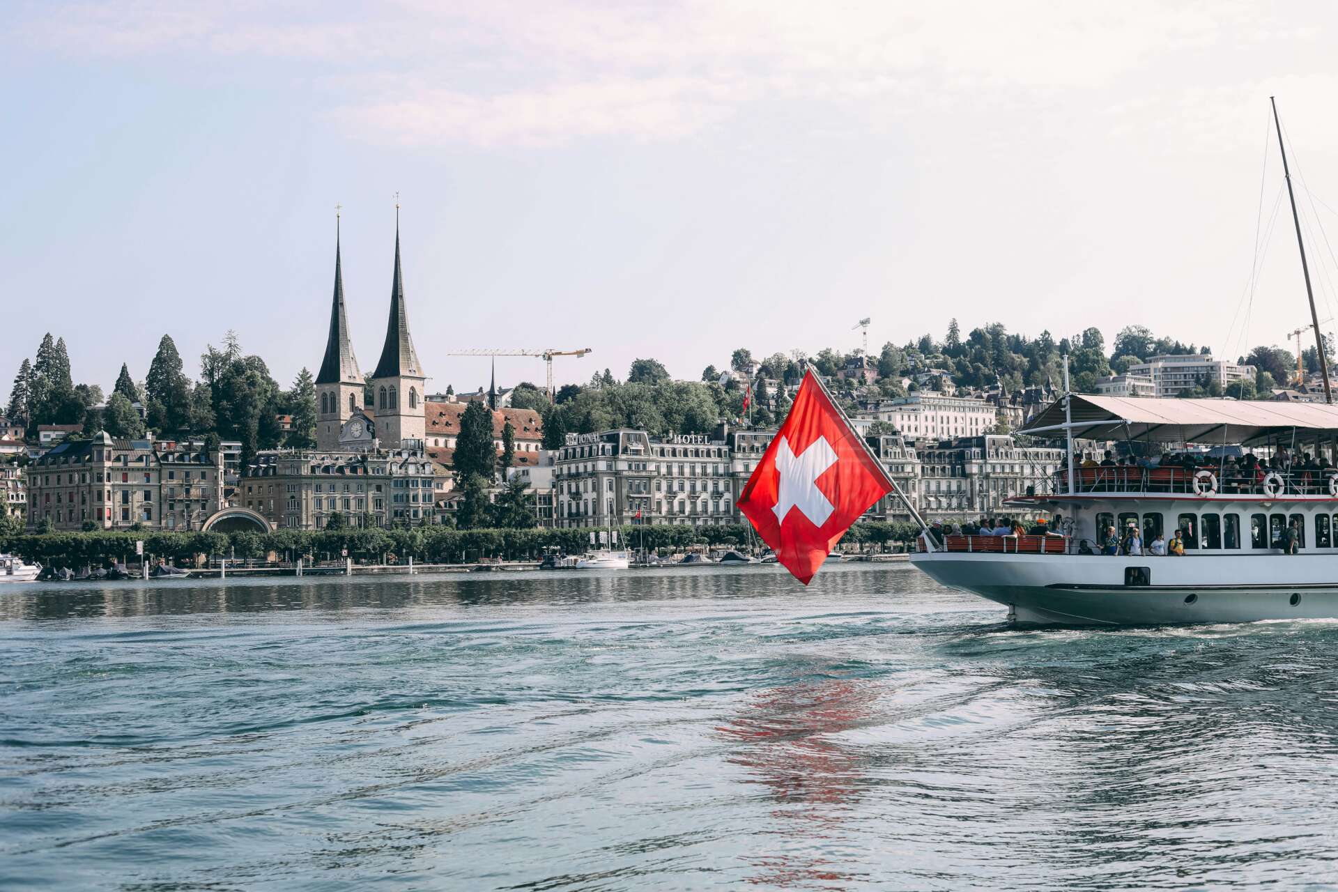 Schiff auf dem Vierwaldstättersee mit Schweizer Flagge vor der Altstadt von Luzern