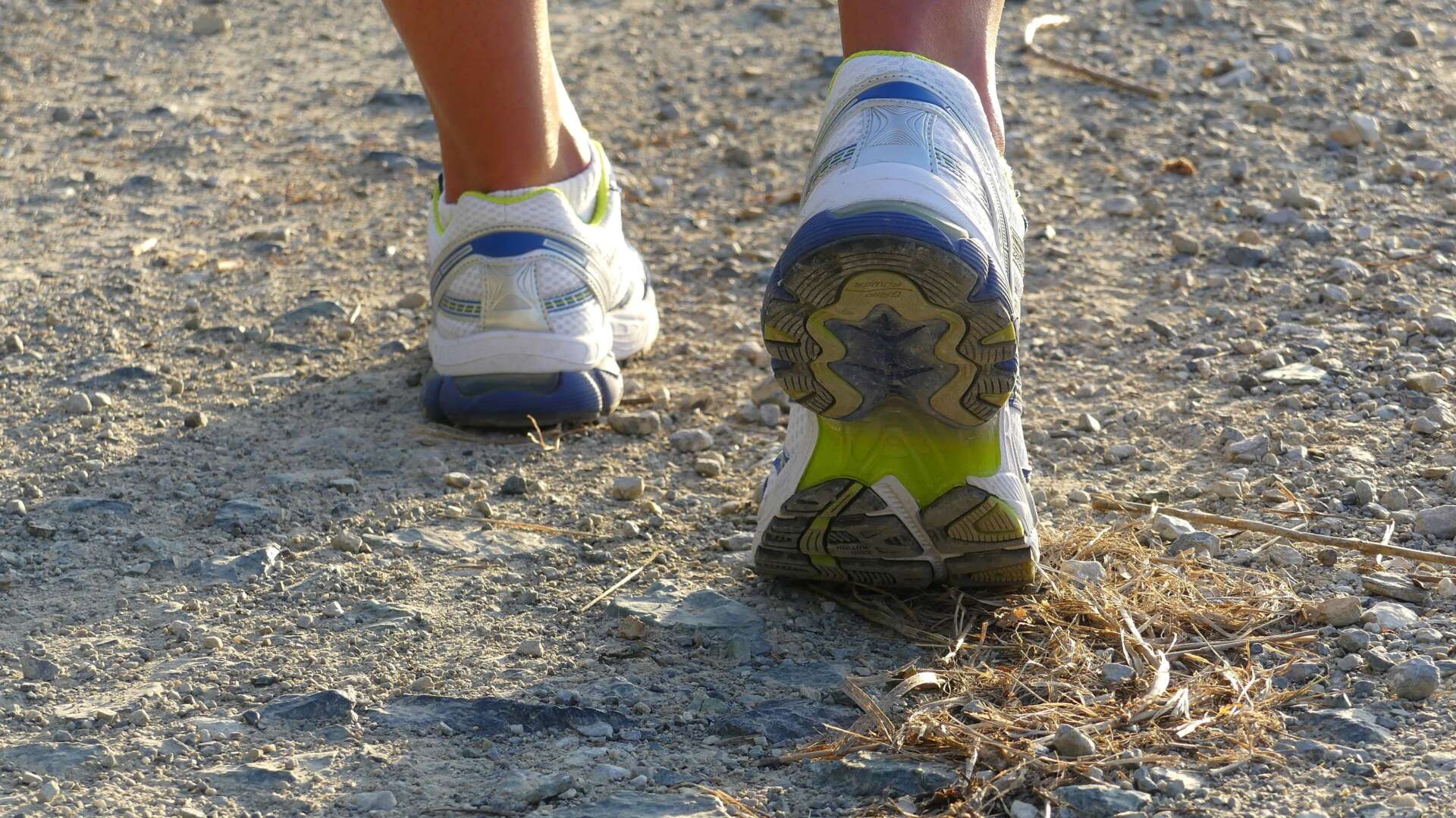 Nordic-Walking-Schuhe auf einem Schotterweg beim Gehen in der Natur