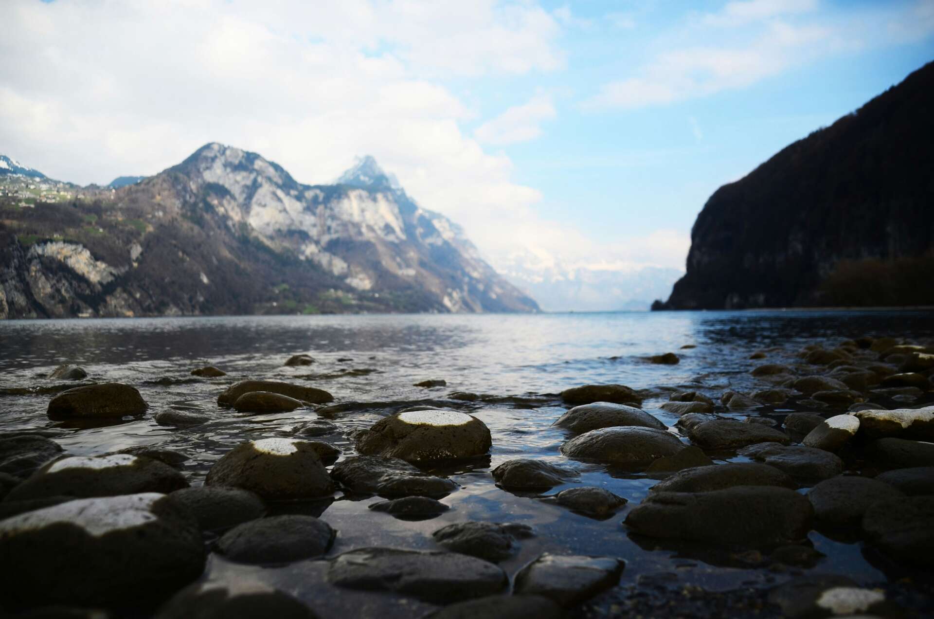 Steiniges Seeufer am Walensee mit Blick auf die umliegenden Berge und das ruhige Wasser.