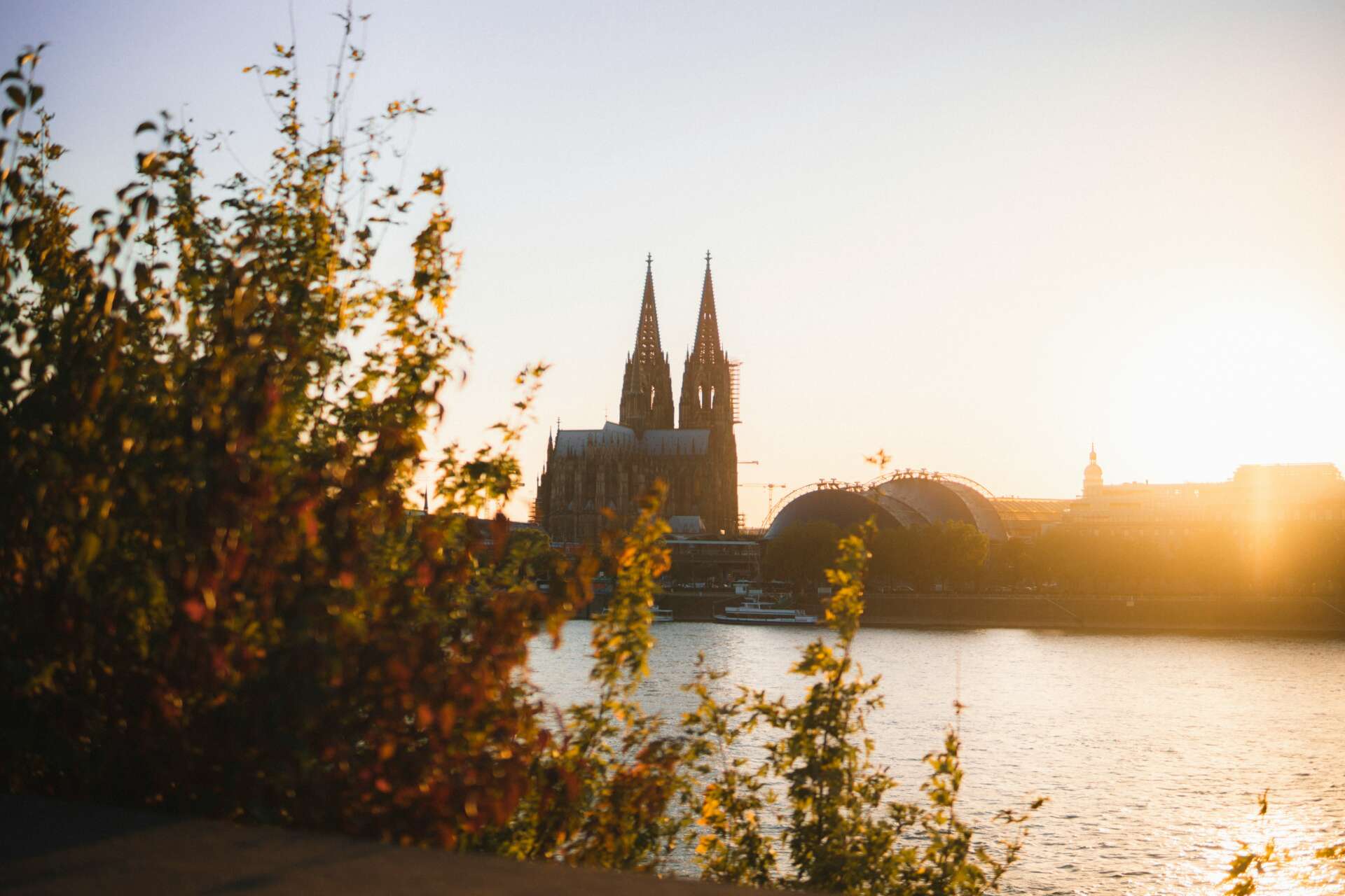 Blick über den Rhein auf den Kölner Dom bei Sonnenuntergang.