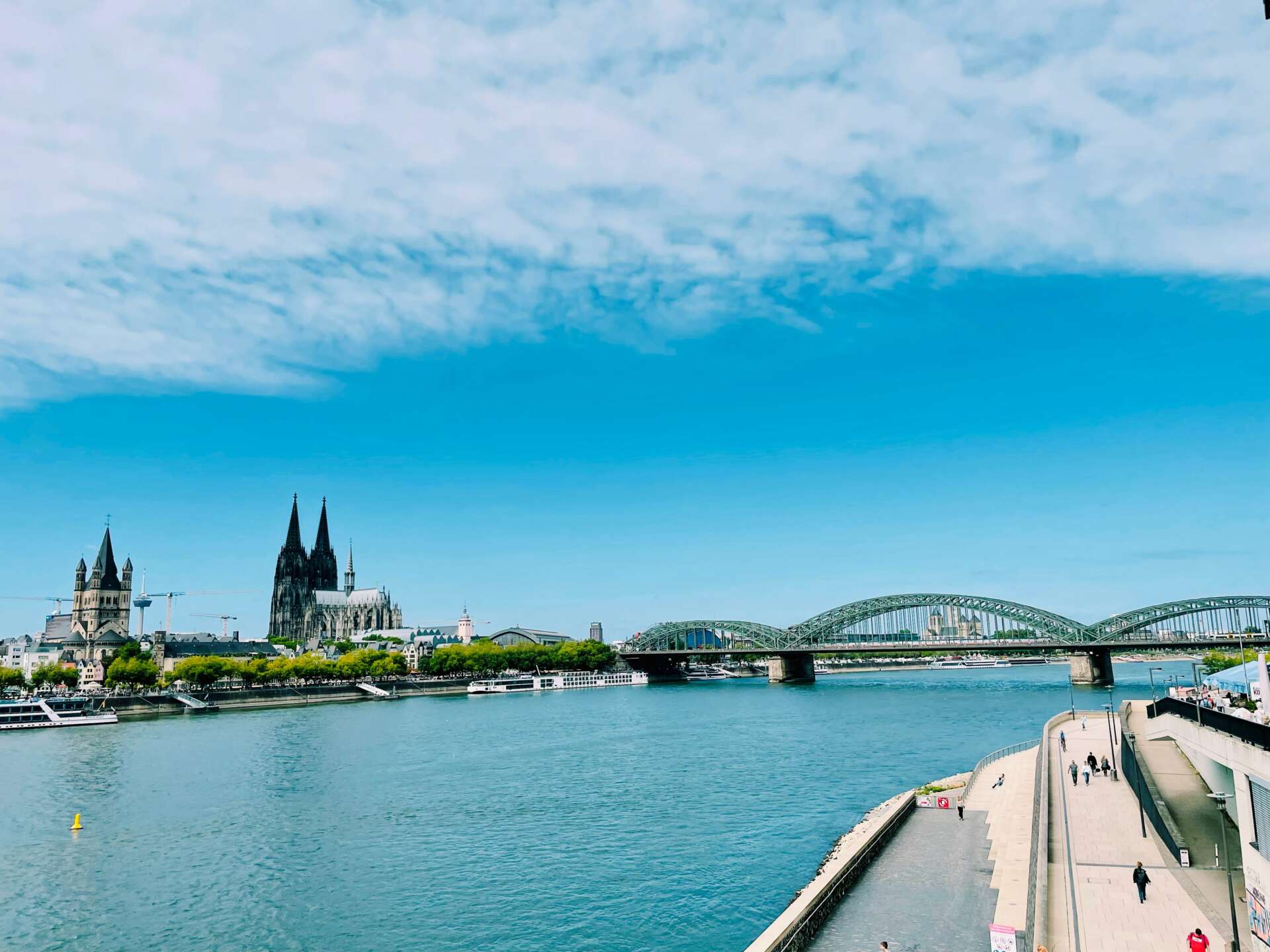 Blick von den Kölner Rheintreppen über den Rhein auf den Kölner Dom und die Hohenzollernbrücke.
