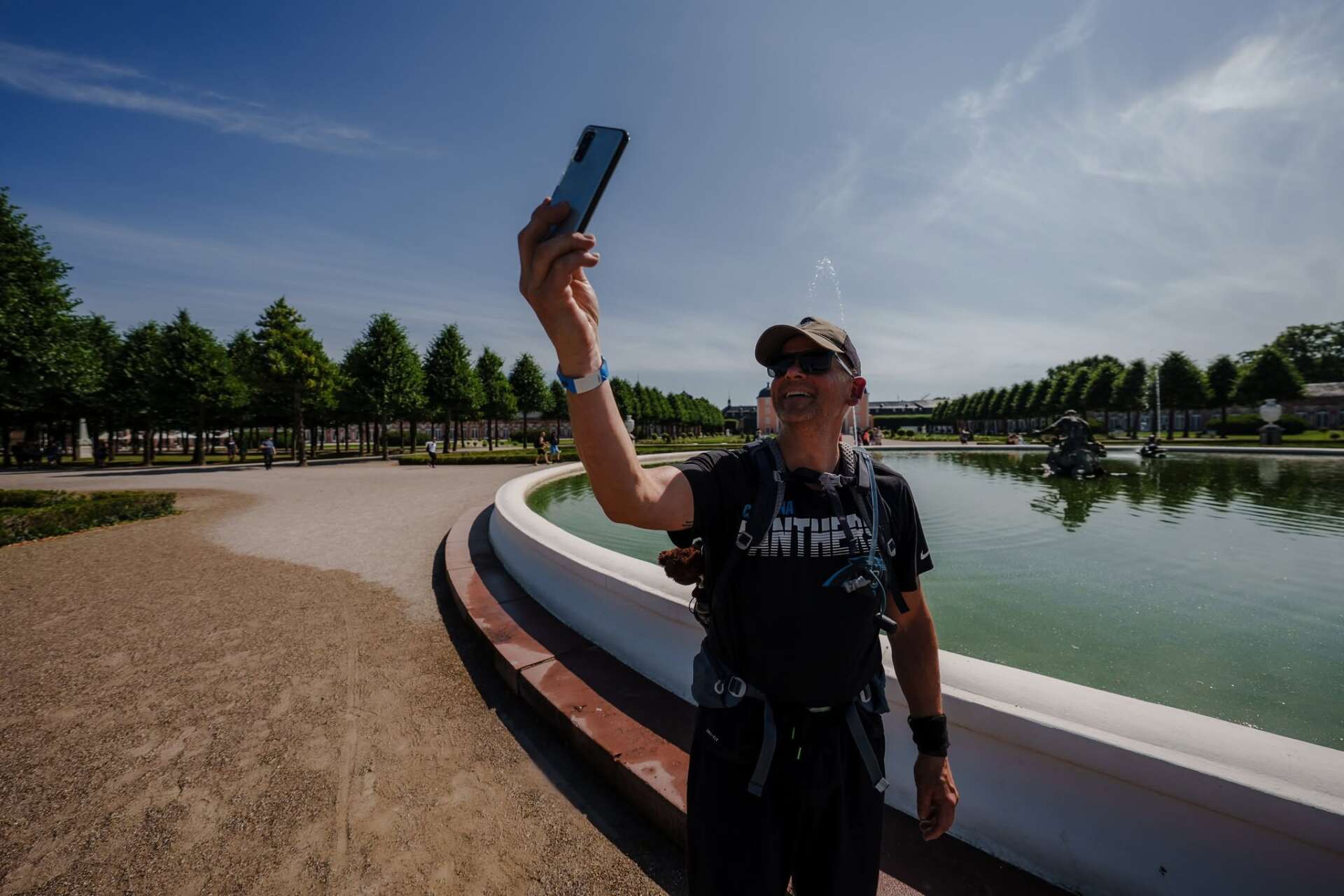 Wanderer mit Rucksack und Smartphone auf einer langen Tour in Deutschland